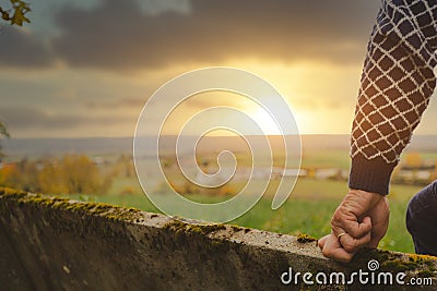 Old manâ€™s hand resting on a bench Stock Photo